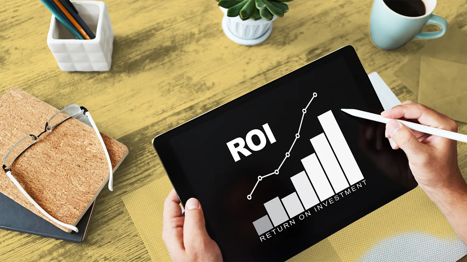 Man holding a tablet with a graph tracking ROI improvement